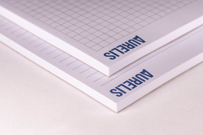 Detailansicht der Notizblöcke im Format A6 von Aurelis, liniert und kariert. Kopfgeleimt ohne Deckblatt, mit 50 Blatt 90 g/m² Naturpapier in Weiß.