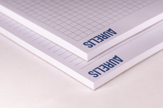 Detailansicht der Notizblöcke im Format A6 von Aurelis, liniert und kariert. Kopfgeleimt ohne Deckblatt, mit 50 Blatt 90 g/m² Naturpapier in Weiß.