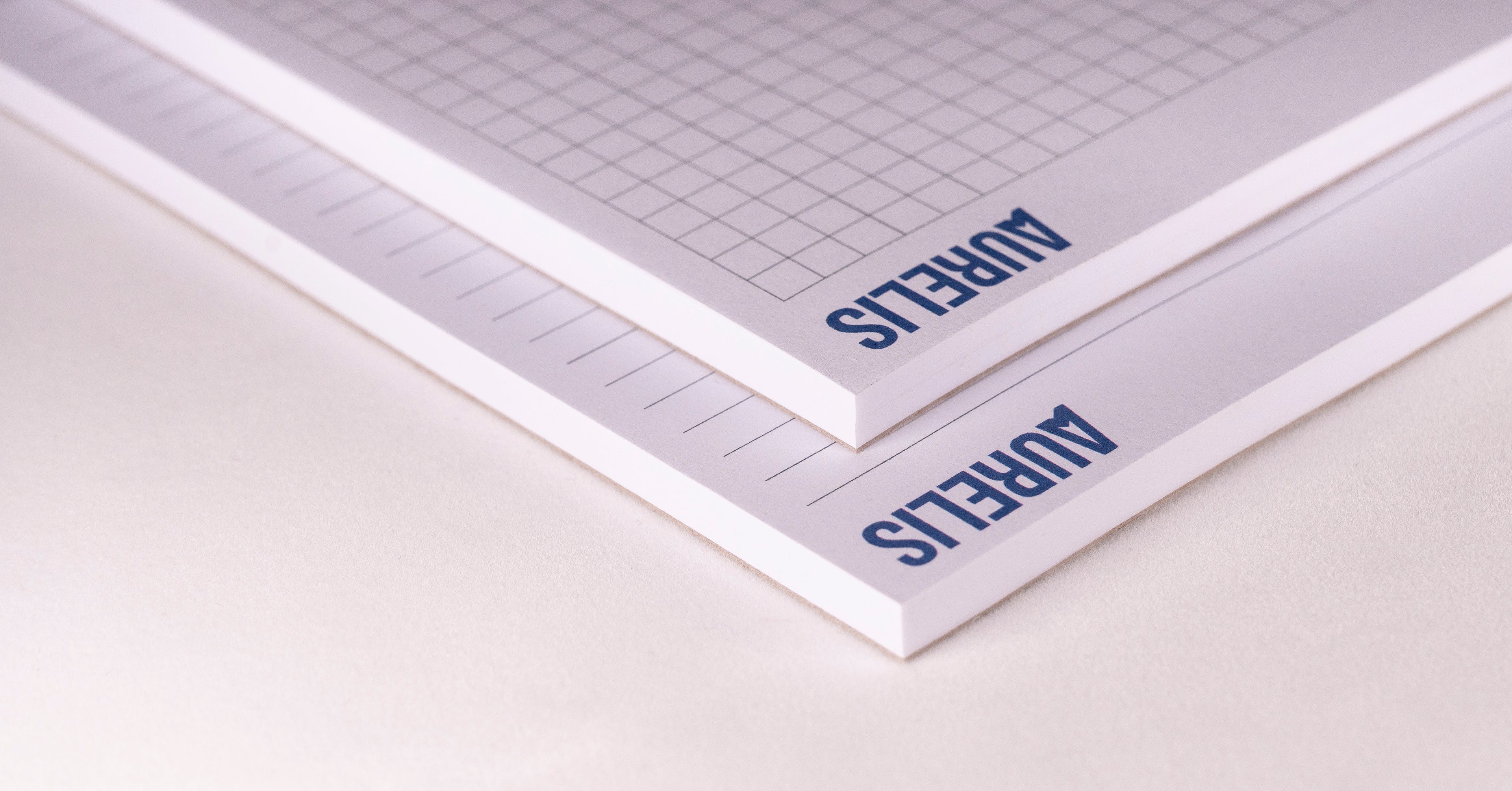 Detailansicht der Notizblöcke im Format A6 von Aurelis, liniert und kariert. Kopfgeleimt ohne Deckblatt, mit 50 Blatt 90 g/m² Naturpapier in Weiß.
