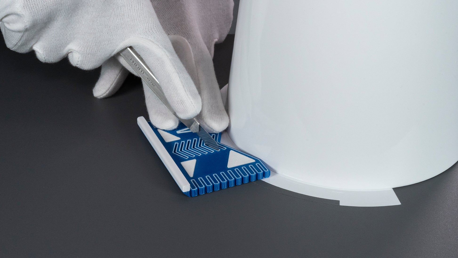 Person mit Cuttermesser schneidet exakte Radien und an runden Objekten mit dem Versatzschneider-961. Ideal für gleichmäßige Abstände der Folie bei runden objekten.